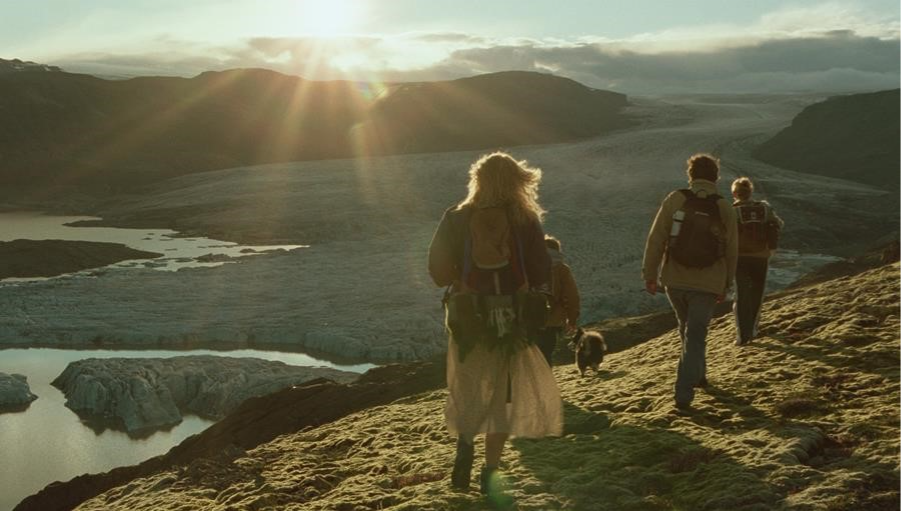 Four people and a dog climbing a mountain in the film The Love That Remains.