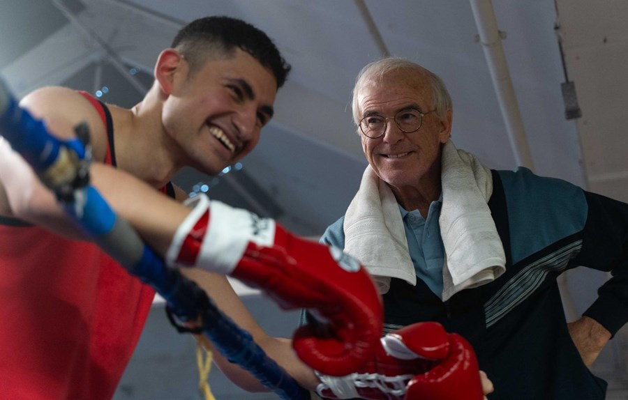 A boxer and his coach smiling on the side of the ring in the film Giant.