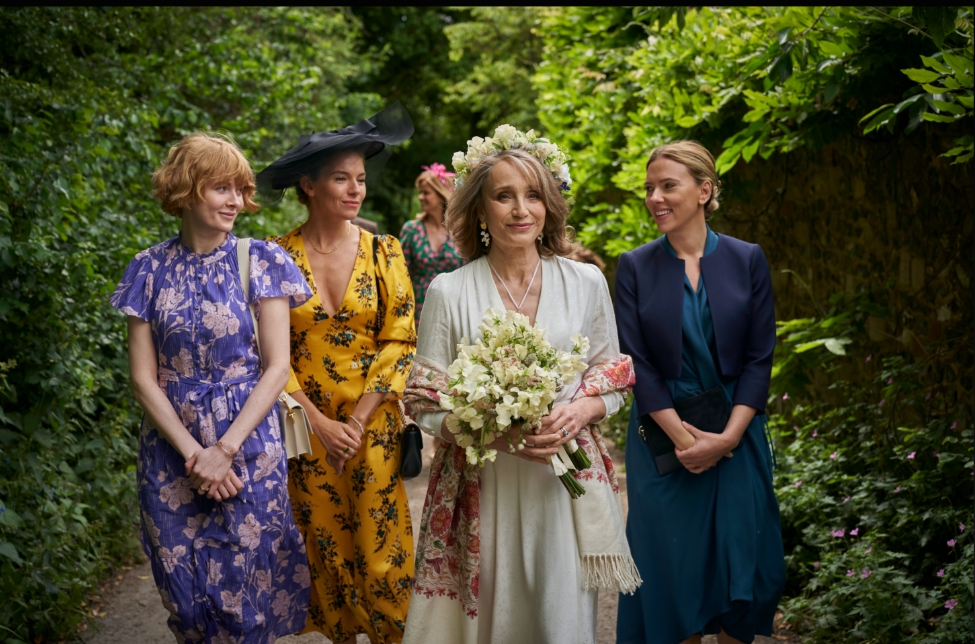 A bride in a white dress walking outdoors with her three daughters in the film My Mother's Wedding.