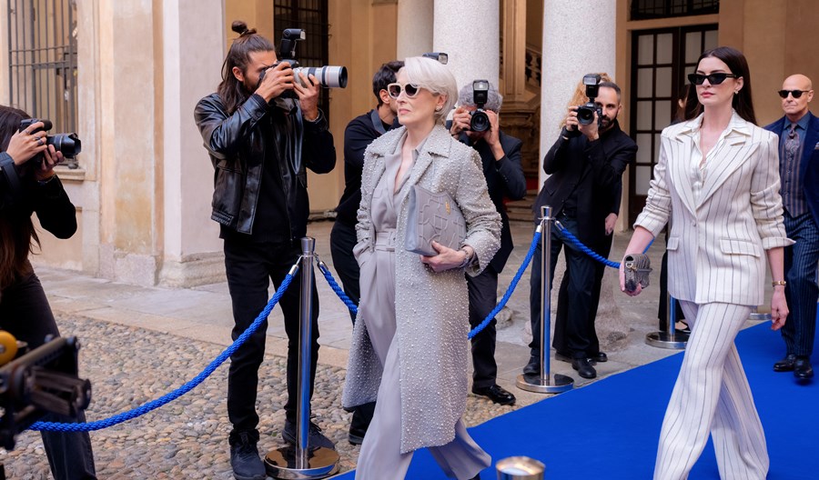 Meryl Streep and Anne Hathaway strutting down a blue red carpet in the film The Devil Wears Prada 2.